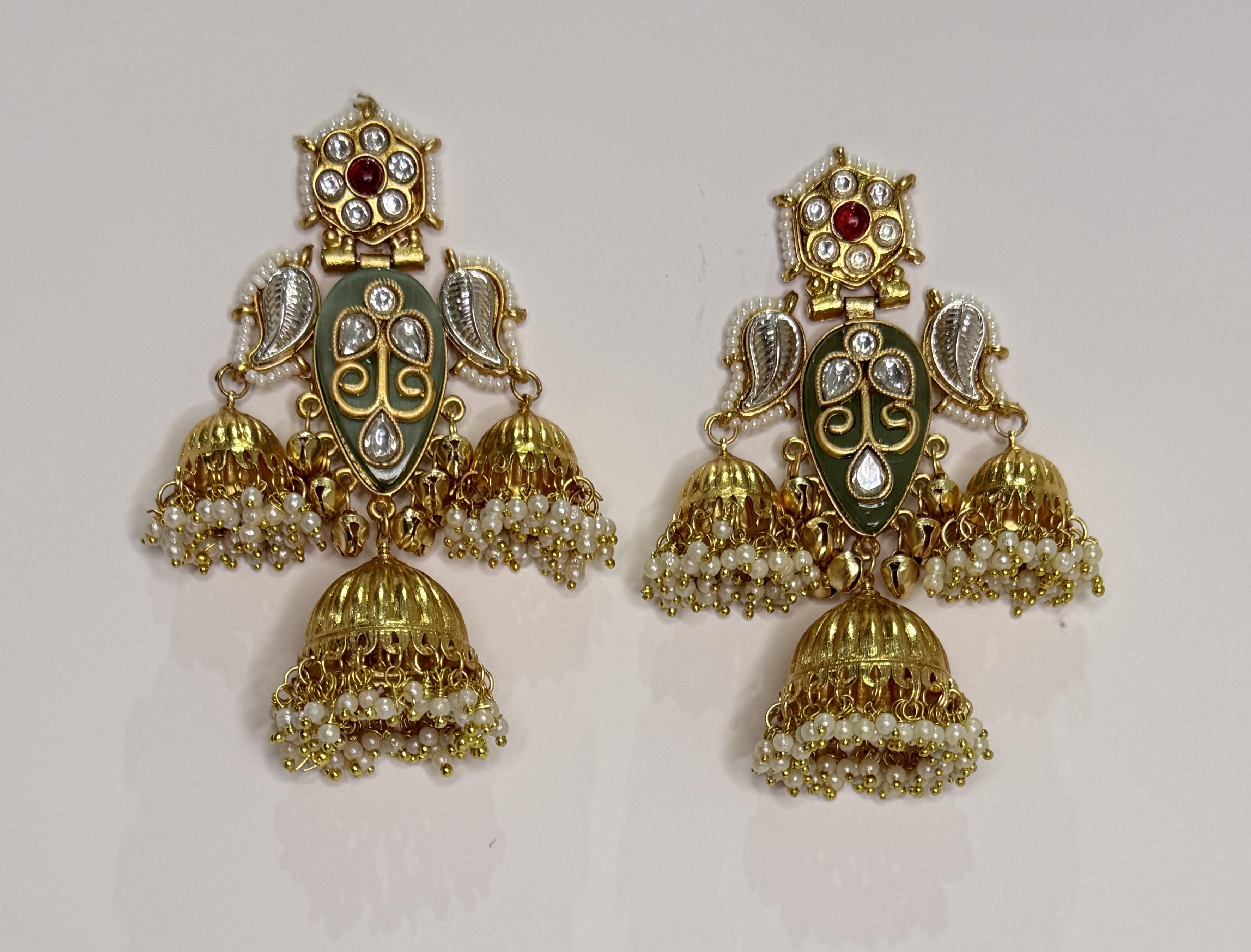 Close-up of mint green Kashmiri earrings featuring intricate gold detailing.